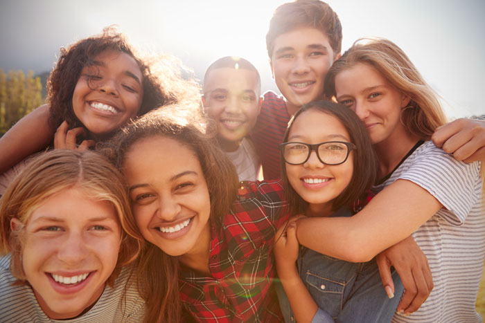 teenage school friends smiling to camera close up